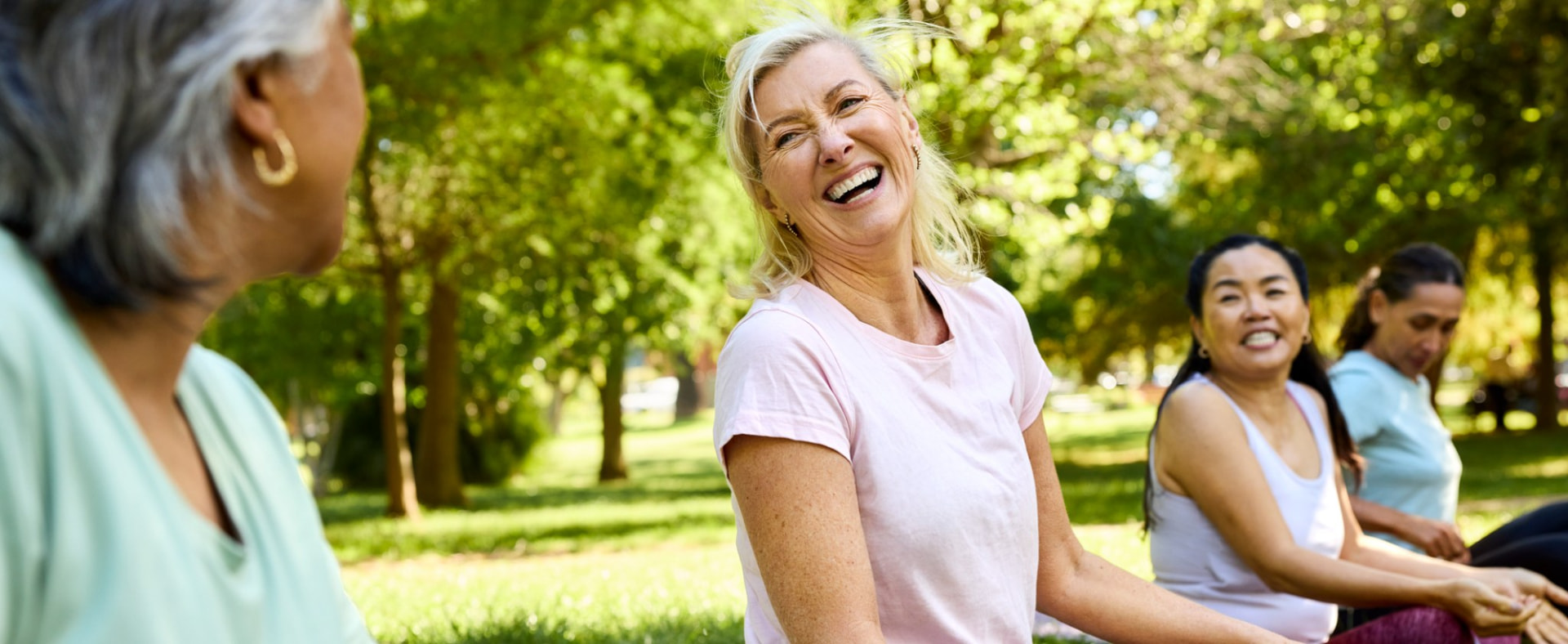 Women laughing together during an outdoor stretching class