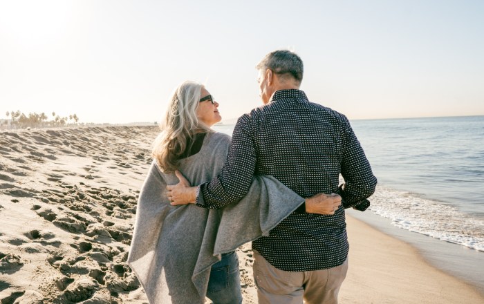 Couple walking together along the beach at sunset